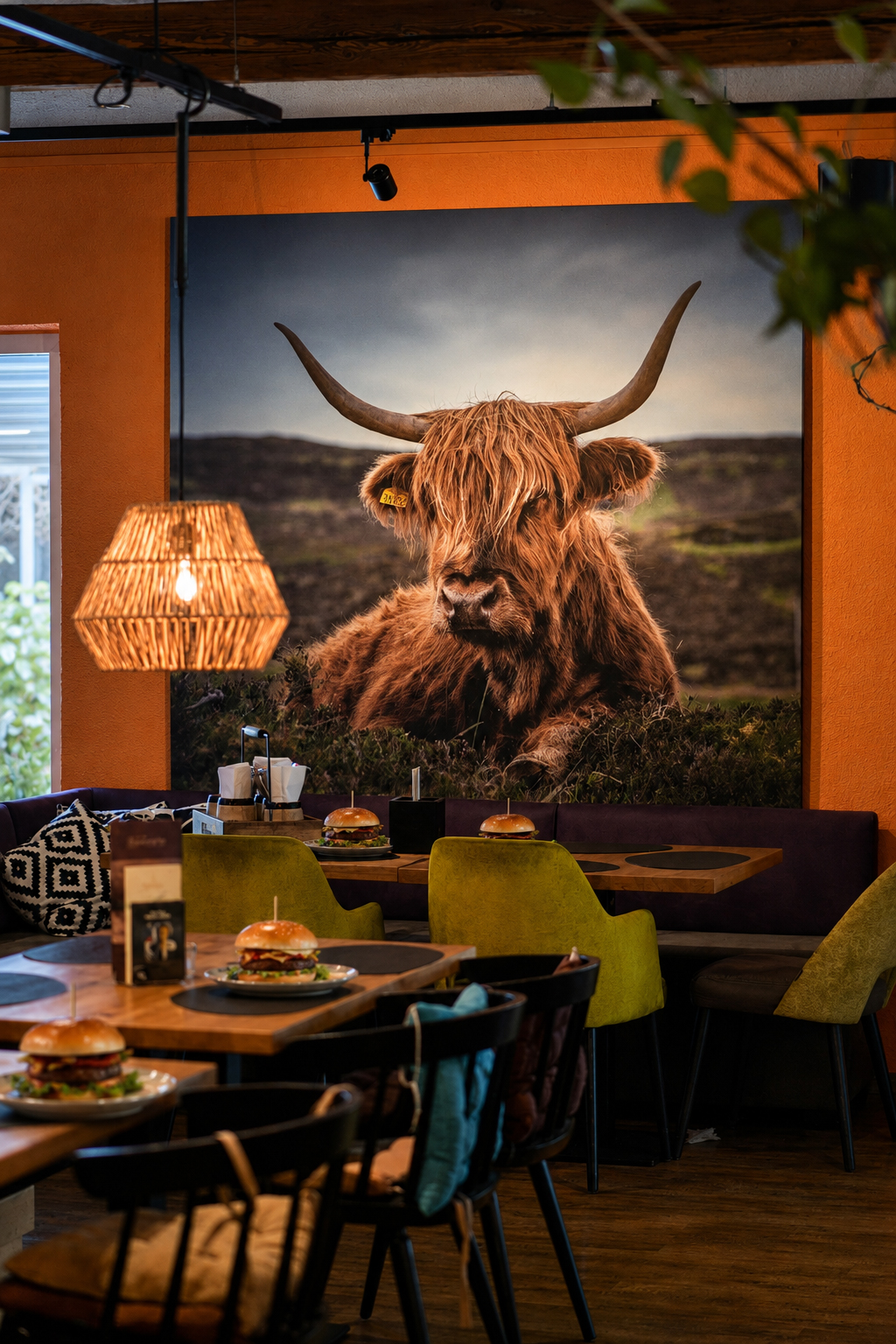 Burger vor Highland-Rind-Wandbild im BullsHouse Rottweil